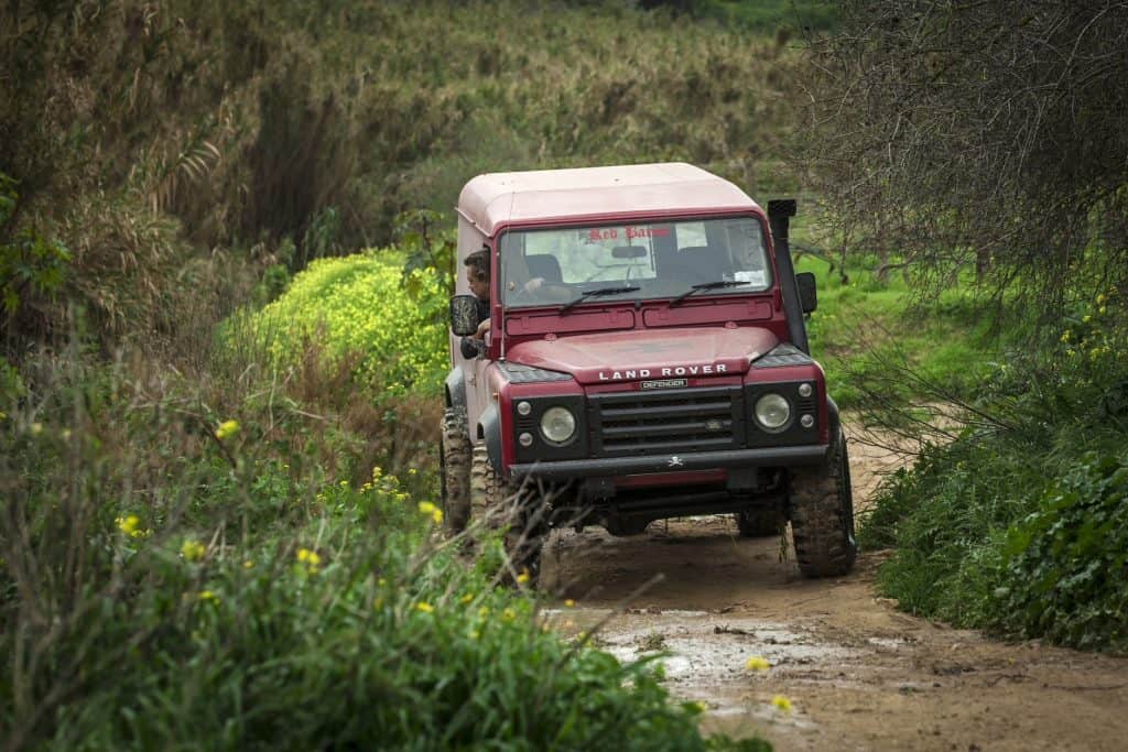 RABAT, MALTA - JANUARY 19, 2014: A 1989 Land Rover Defender wades through deep rain water. The Defender is one of the most off-road capable vehicles in history.
